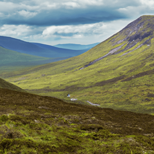 Dramatic landscape of the Scottish Highlands with towering mountains, rocky peaks, and lush green valleys